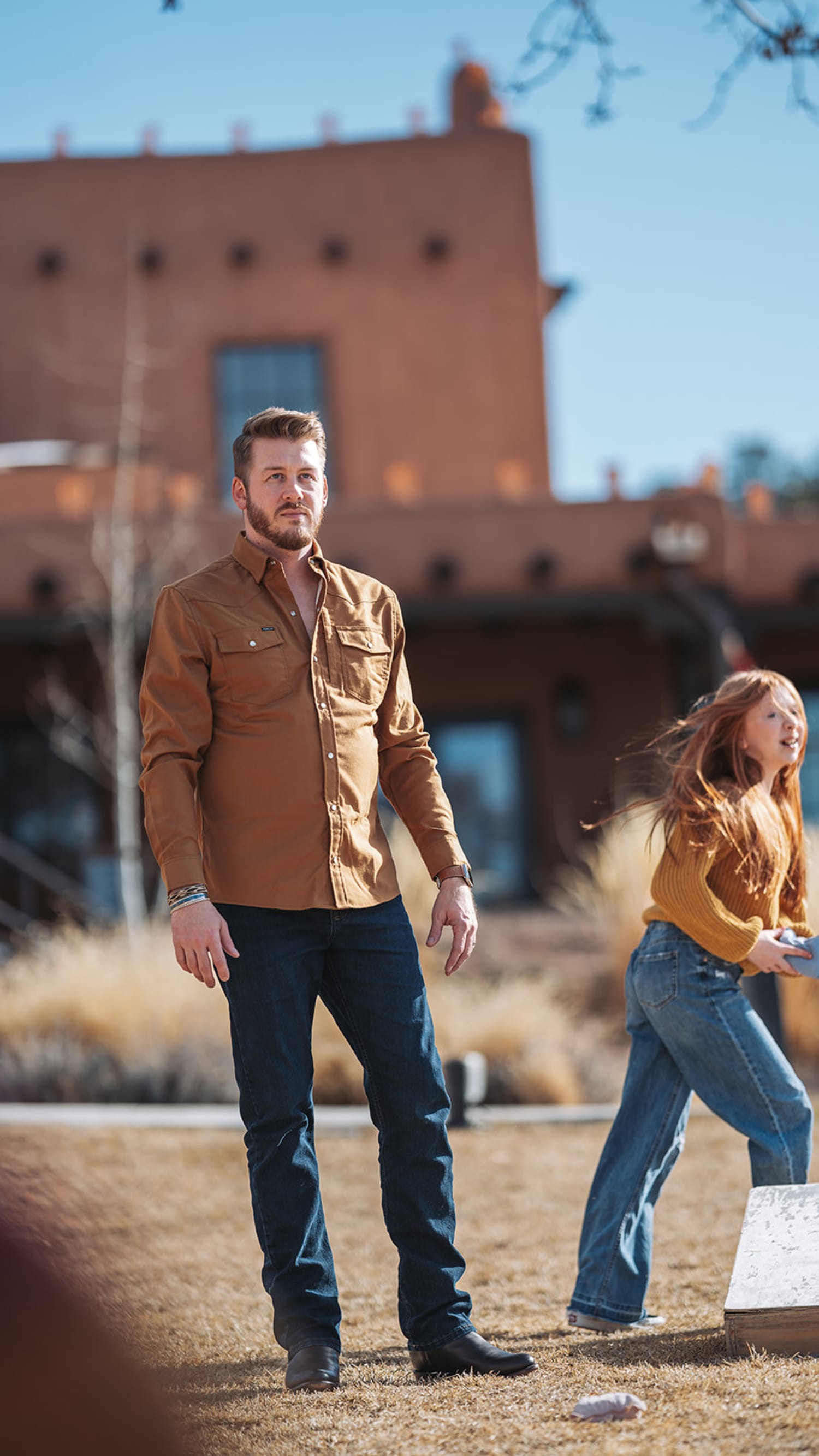 portrait session documents a man and girl posed against a striking red-brick adobe structure chara... — Casey Addason Photography