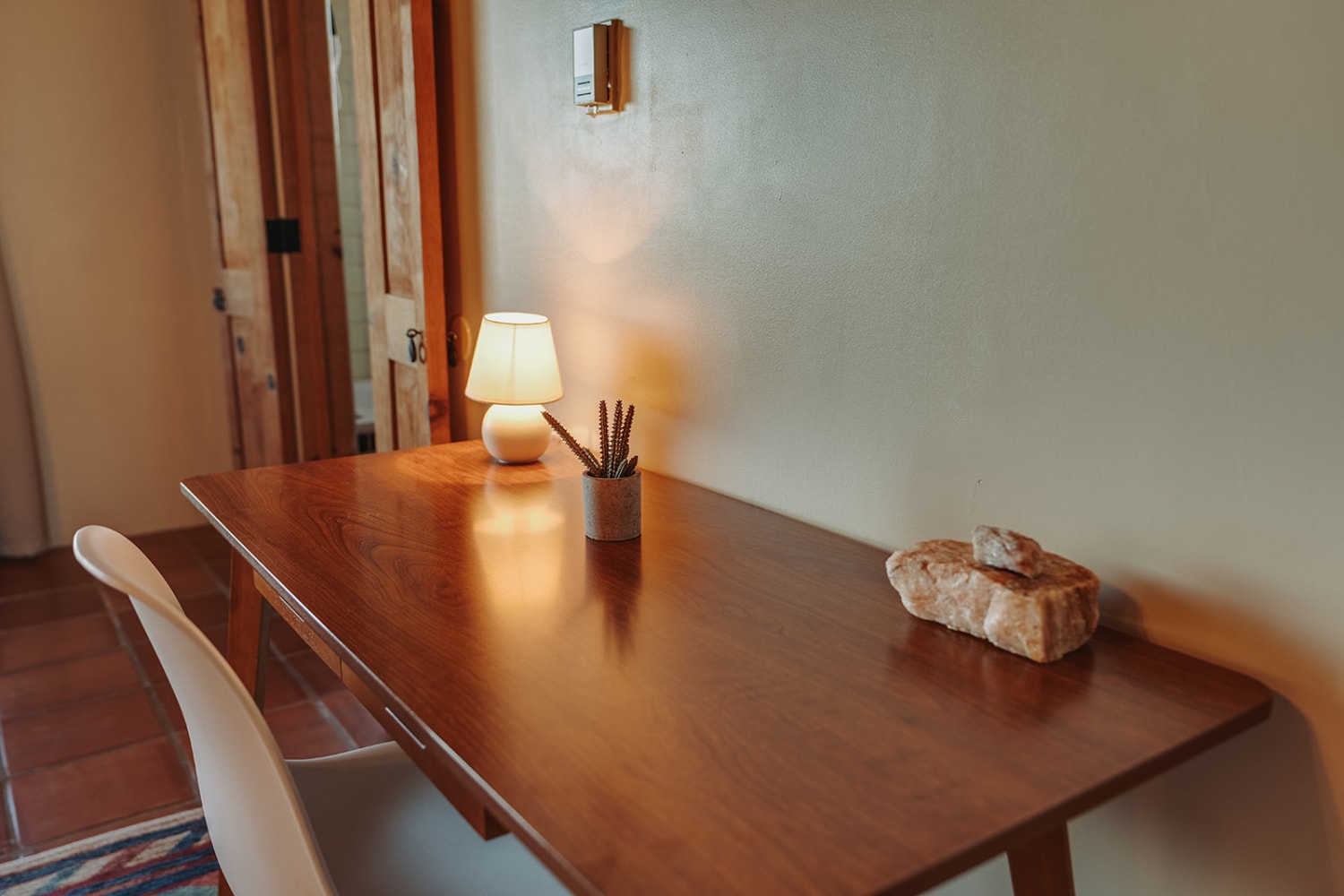 photograph documents a minimalist home office or study nook bathed in warm, golden-hour sunlight s... — Casey Addason Photography