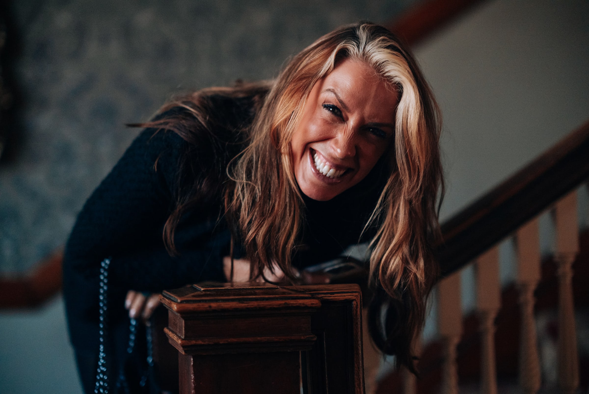 Women posing on the columned porch of The Stanley Hotel with mountain views behind