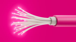 Hehkuva vaaleanpunainen valokaapeli, jossa on valaistuja säikeitä kirkkaan vaaleanpunaisella taustalla.
