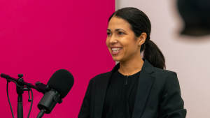 Amel Gaily juontamassa Johtoajatuksia-podcastia studiossa mikrofoni edessään.