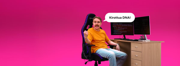 Oranssipaitainen mies istuu tietokonepöydän ääressä ja sanoo kirkkaanpinkillä taustalla Kirottua DNA!.