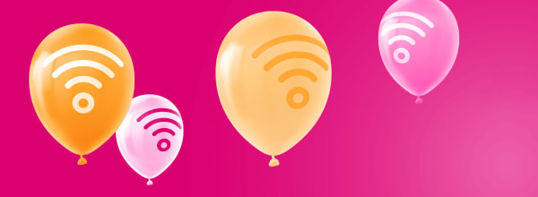 Oransseja ja vaaleanpunaisia ilmapalloja, joissa on wifi-symboleja, leijuu kirkkaan vaaleanpunaisella taustalla.