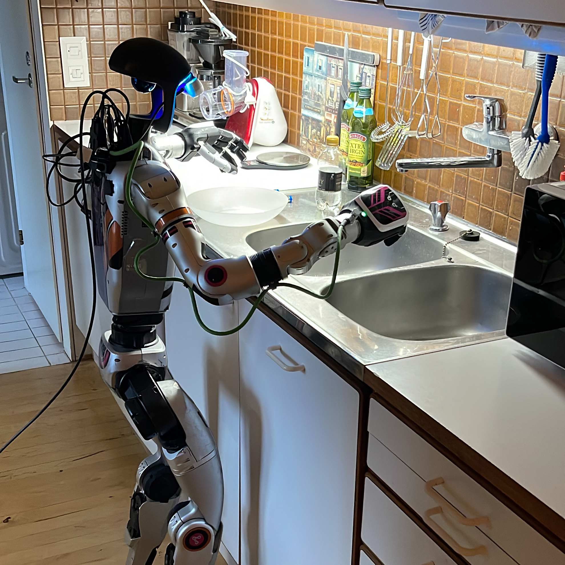 Humanoidirobotti pesee astioita keittiössä.