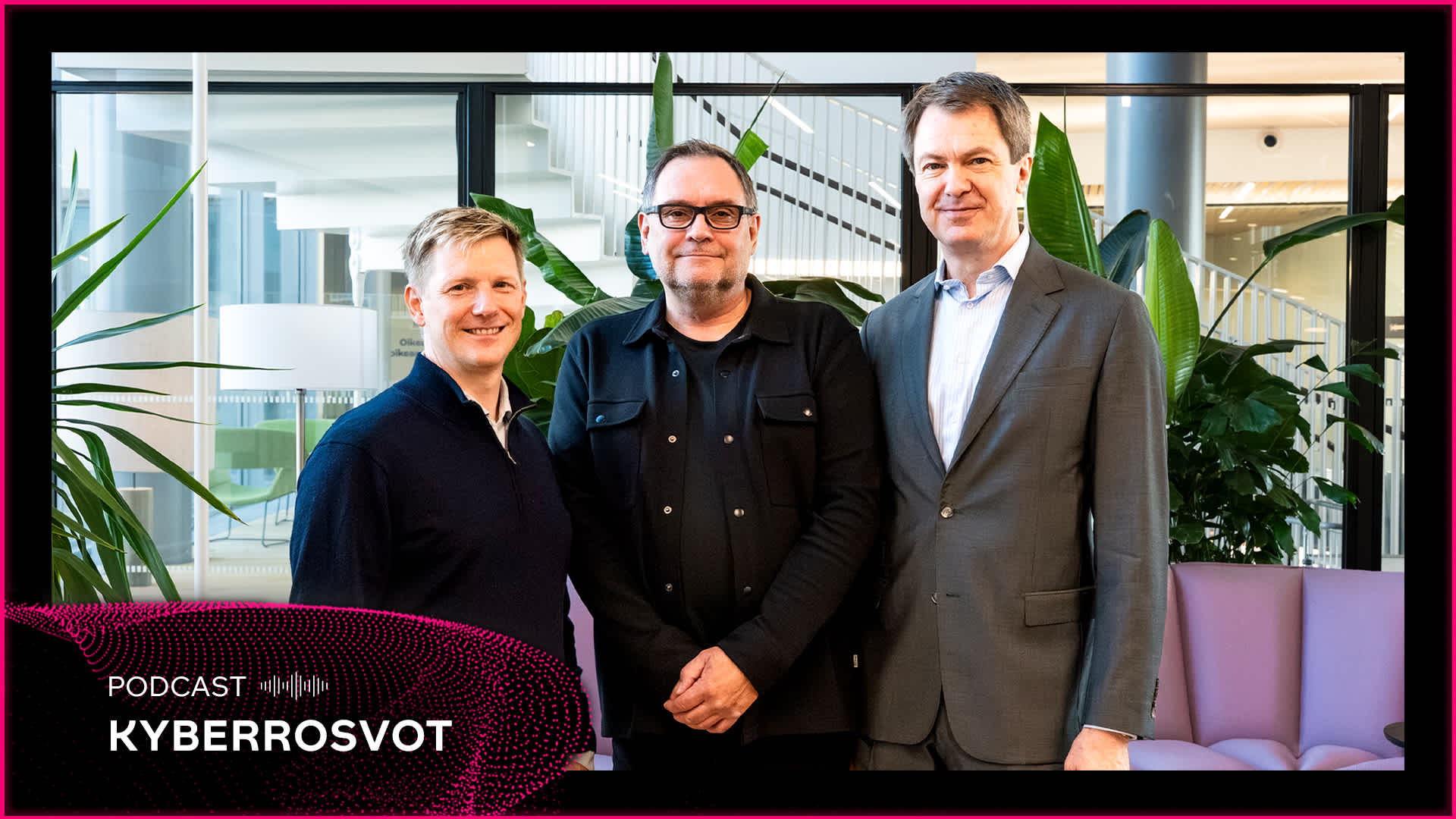 Kolme miestä seisoo ja hymyilee toimistoympäristössä, jossa on kasveja ja moderni sisustus, tekstissä lukee Podcast Kyberrosvot.