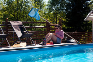 Nainen soittaa ulkomaille altaan laidalla