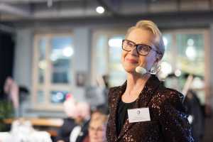 Viestintätoimisto Riannon toimitusjohtaja Riitta Auvinen puhuu mikrofoniin sisätiloissa.
