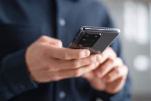 Lähikuvassa mies, jolla puhelin kädessä