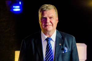 Aapo Ceberberg seisoo ja katsoo kameraan, tumma tausta