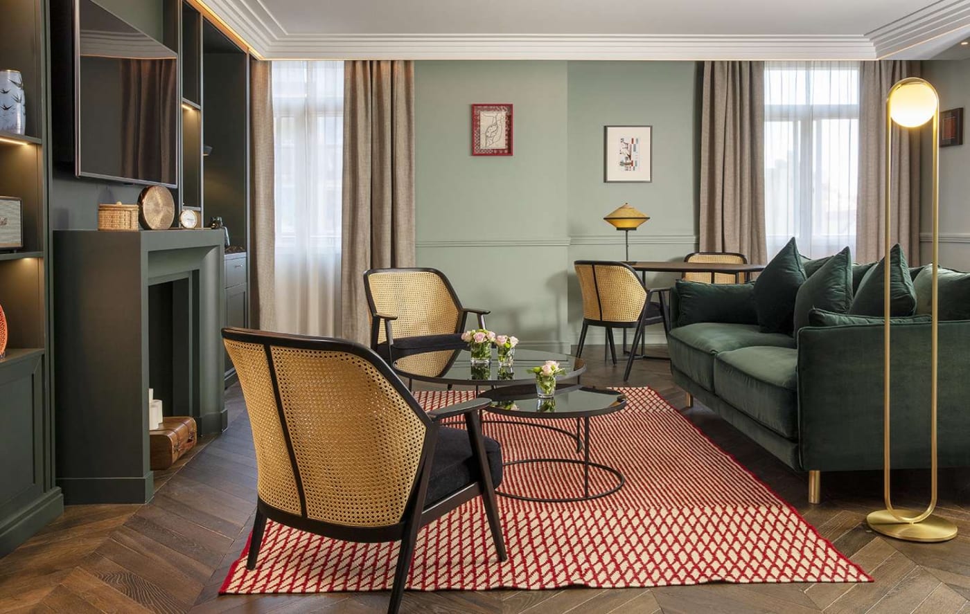 The living room of a suite at the Maison Rouge, caned armchairs and fireplace