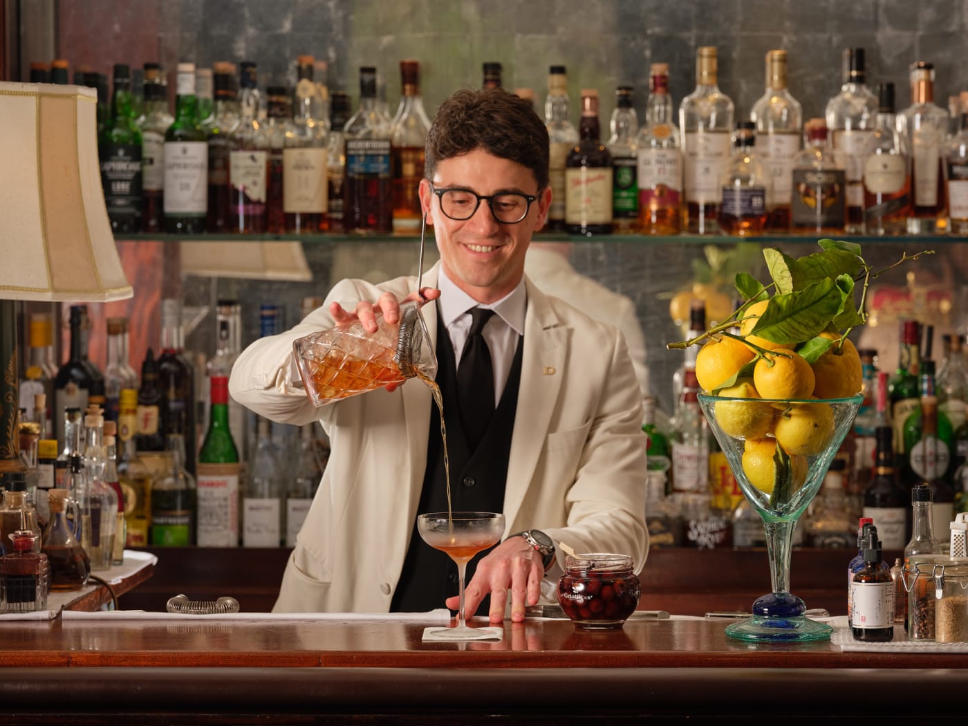 A bartender at Dukes Bar prepares a cocktail at the counter