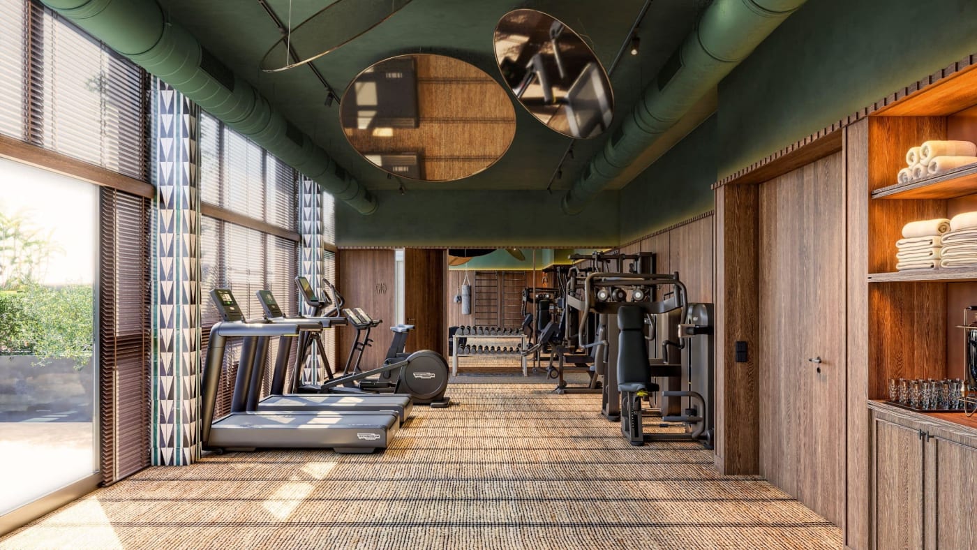 The gym at Thompson Sevilla, treadmills beneath a green ceiling
