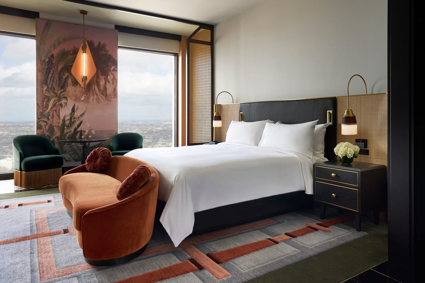 Una habitación con cama king del Fairmont New Orleans, sillones verdes y vistas a la ciudad