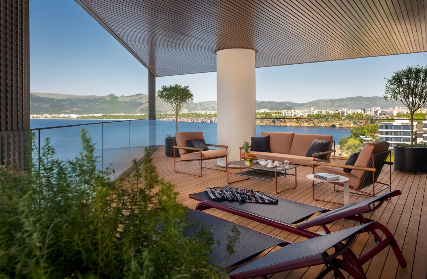 Große Terrasse einer Sunset Suite mit Liegen und Sitzecke, Blick auf die Küste von Antalya und die Berge