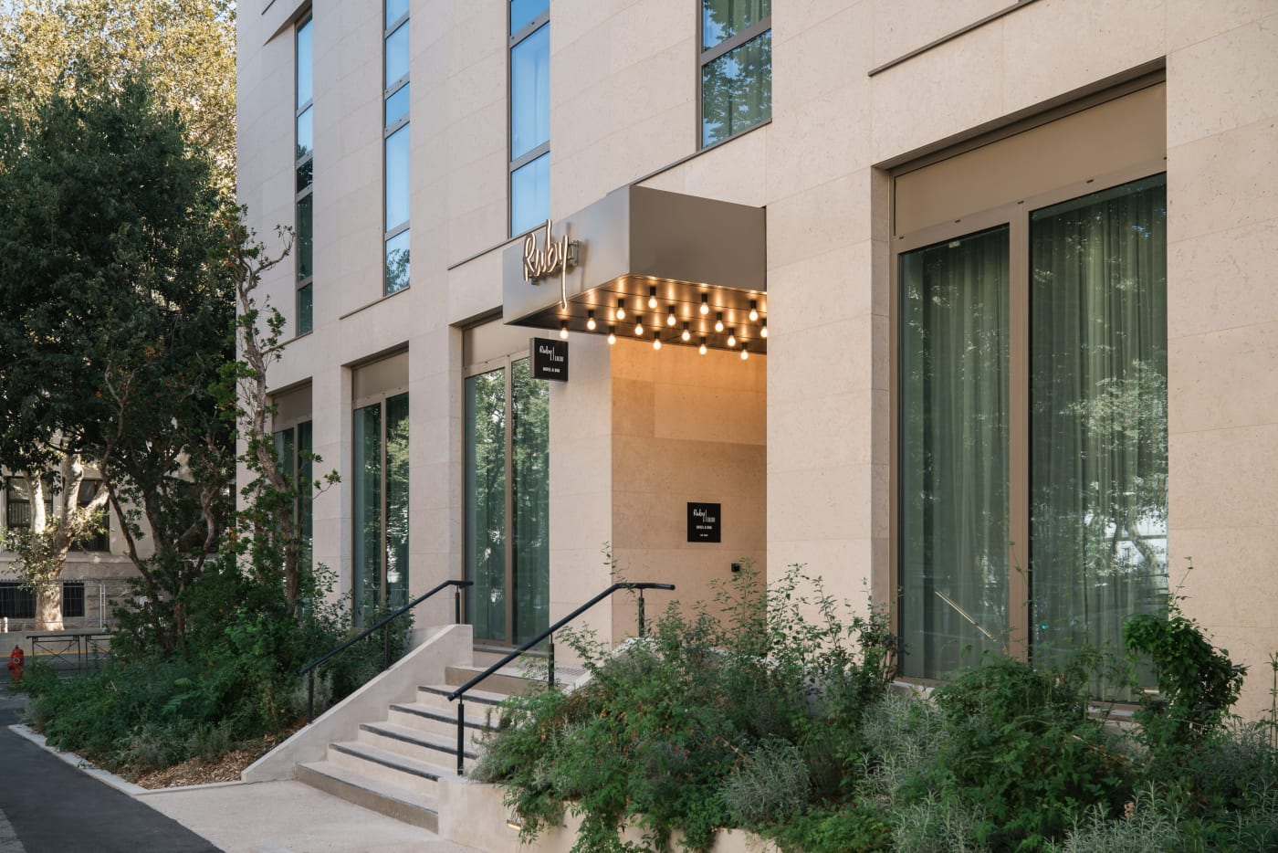 Entrance to the Ruby Lilou hotel on Boulevard des Dames in Marseille, illuminated canopy and light stone facade