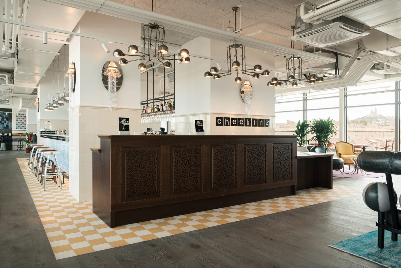 Self-service reception of the Ruby Lilou hotel, carved wooden counter and view of Notre-Dame de la Garde