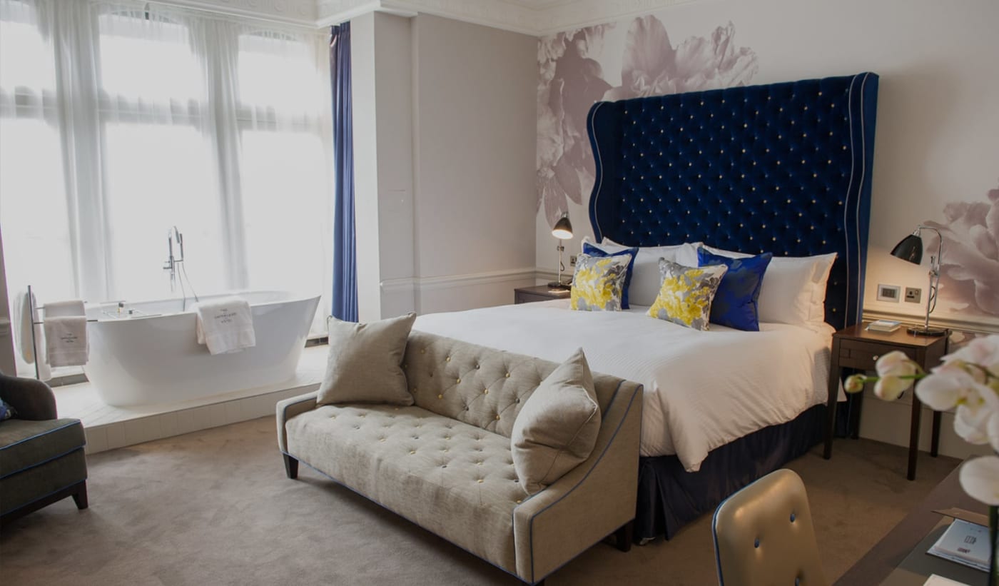 Zimmer im Ampersand Hotel in London mit blauem Samtkopfteil und freistehender Badewanne