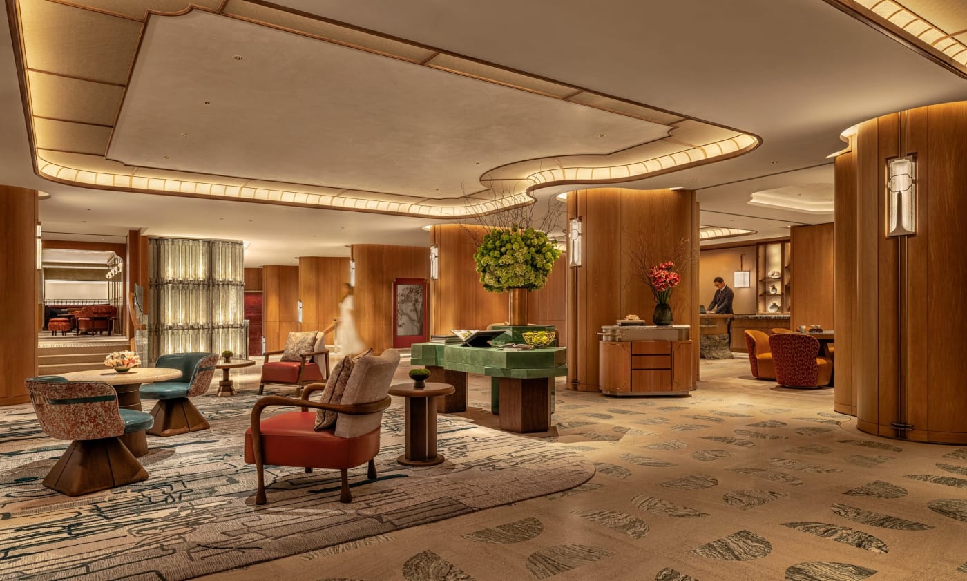 Lobby du premier étage de l'hôtel Mandarin Oriental The Landmark à Hong Kong, redessiné par Joyce Wang dans des tons terre cuite et vert profond