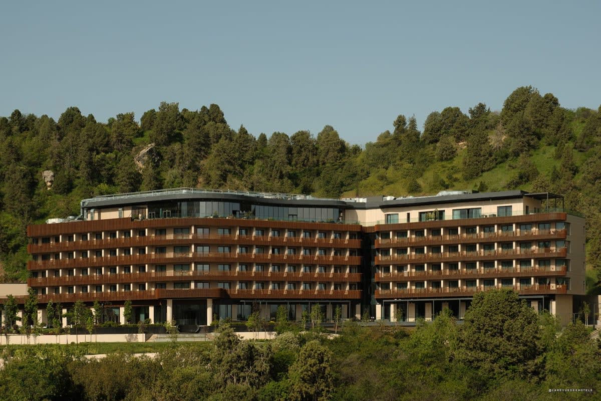 Façade en bois du Beldersoy Resort and SPA au milieu des forêts du Tian Shan
