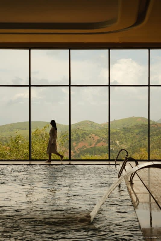 Piscine ouverte sur les montagnes par une verrière toute hauteur
