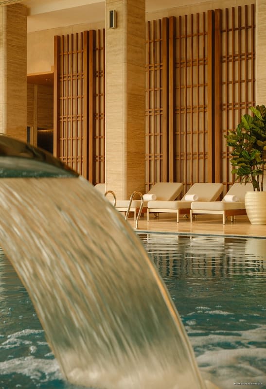 Bassin intérieur du spa re:Thalasso avec jet d'eau et transats en bois