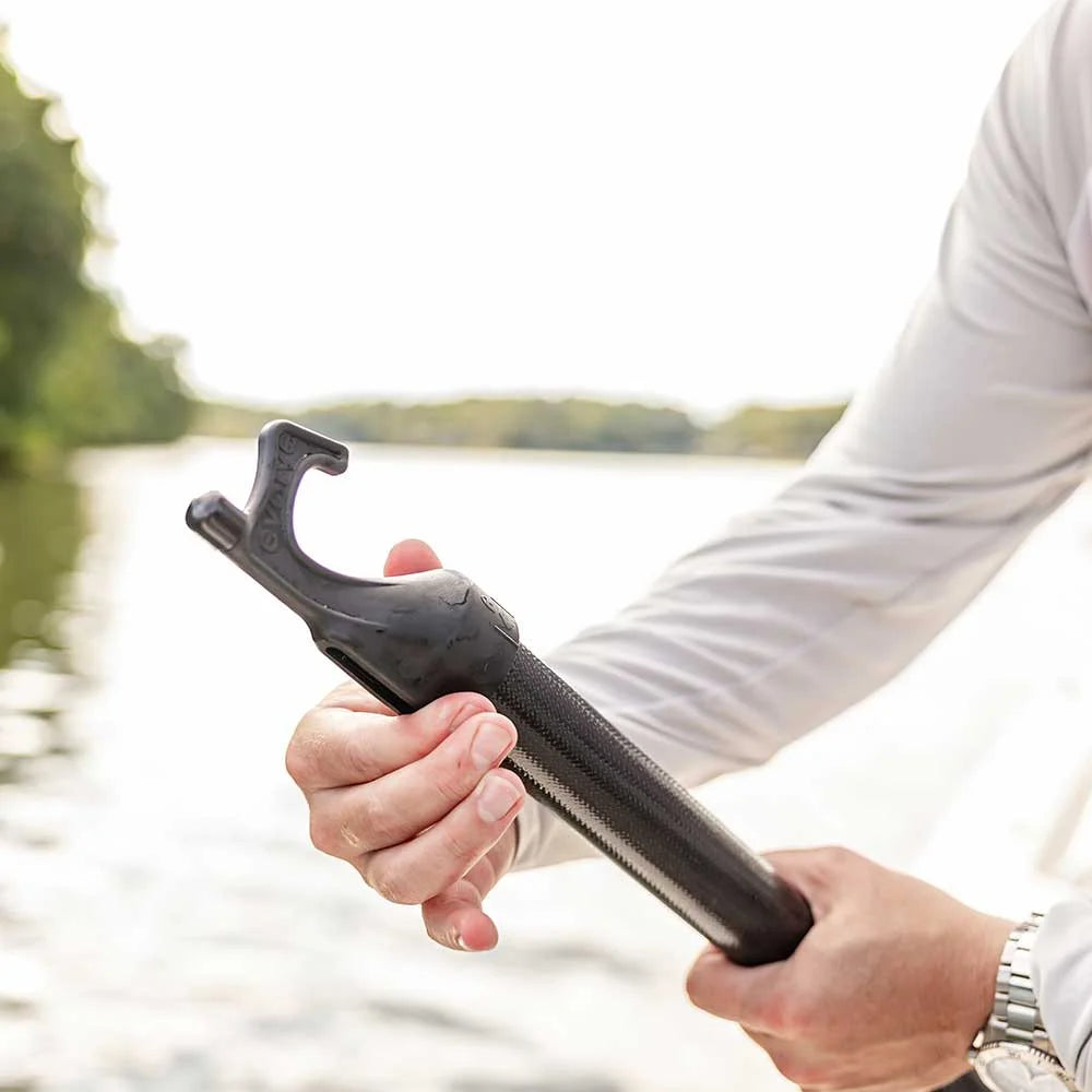 The Revolve Tec boat hook head and composite shaft held in hand by the water