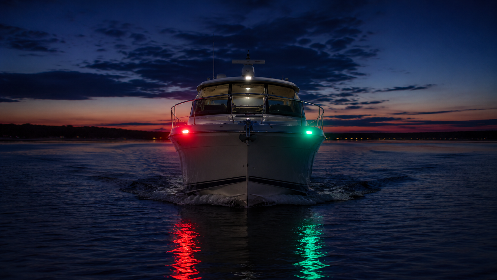 Head-on view of a boat showing red port and green starboard navigation lights at dusk