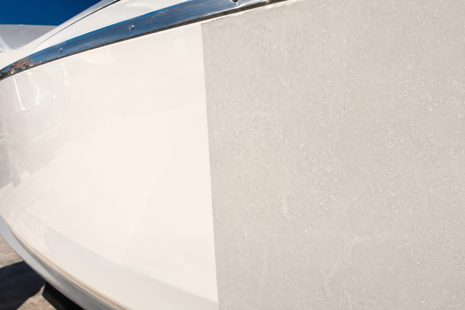 Glossy polished gelcoat next to a dull, chalky, sun-oxidized section of a boat hull
