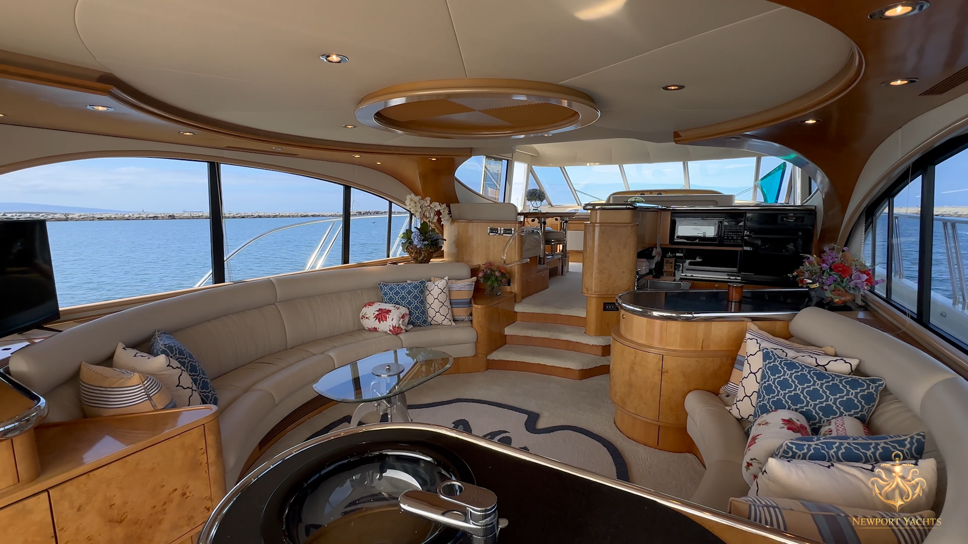 Bright teak-and-burl salon interior of the Nordlund 66 with wraparound seating and prism skylights
