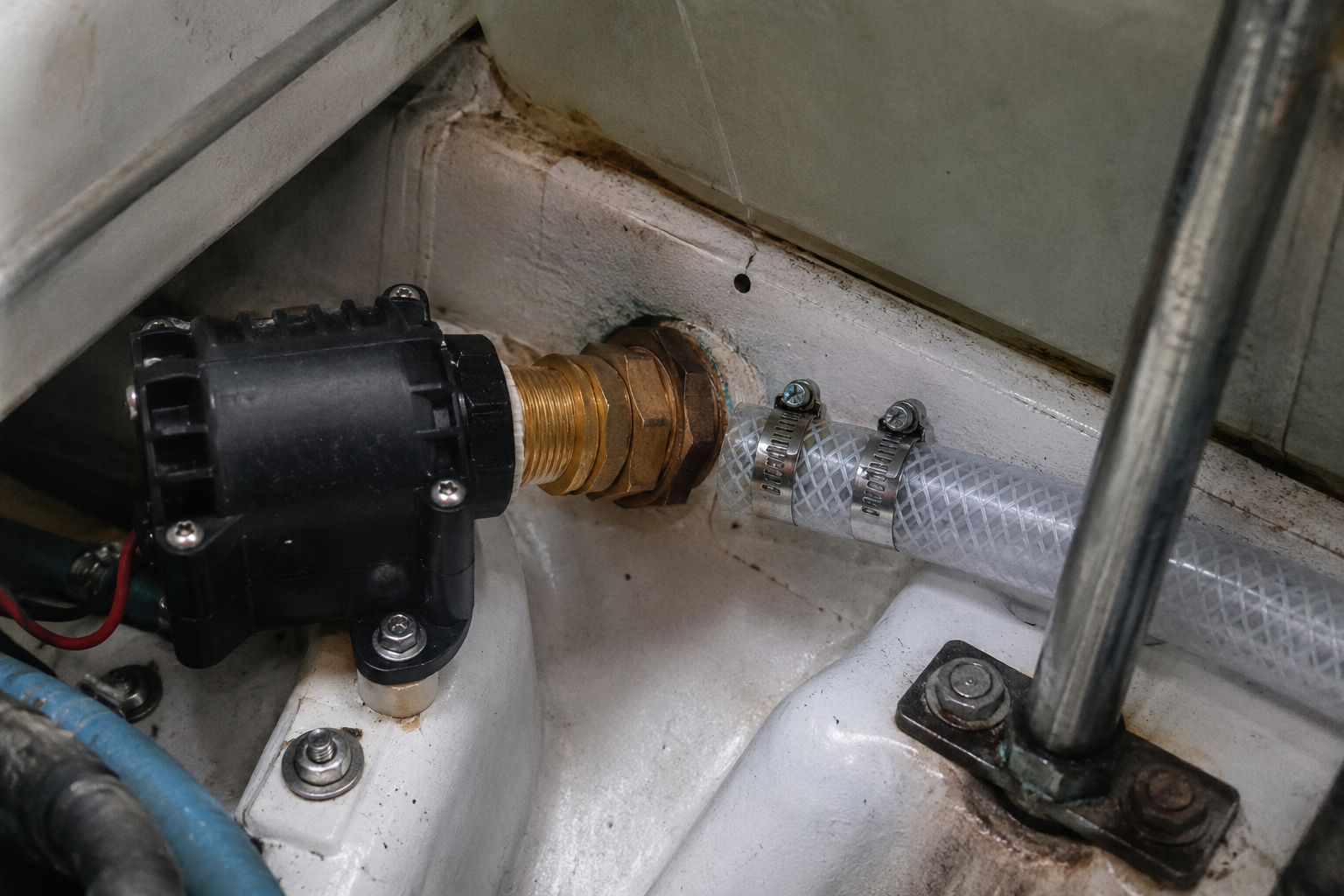 Livewell pump and brass reducer fitting installed on a thru-hull