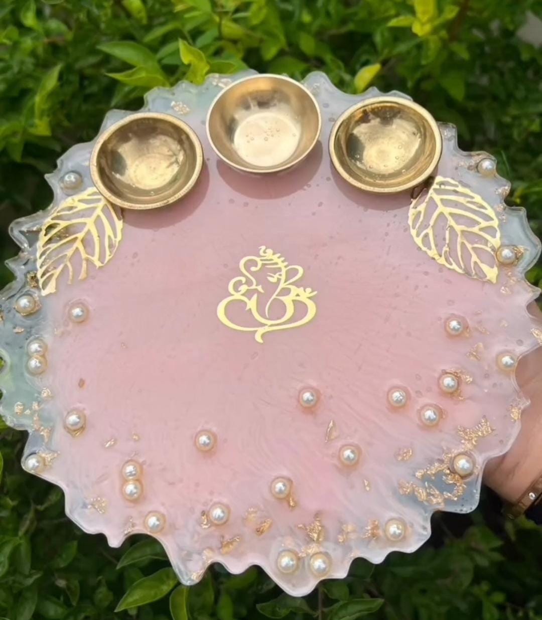 Elegant pink resin pooja thali with handcrafted decorative detailing.