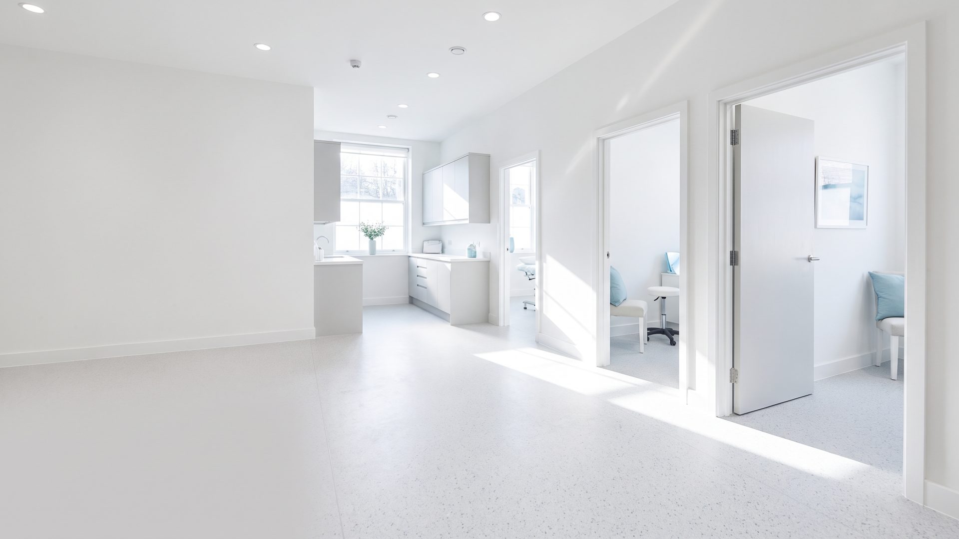 Treatment room doors standing open along the corridor of a new medical aesthetics clinic in Quebec