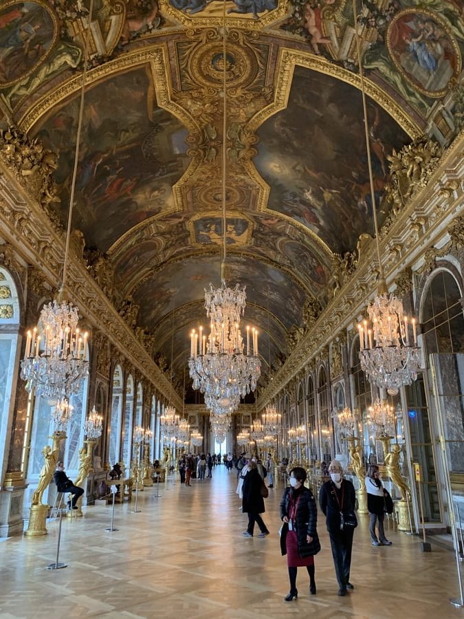 galleria degli specchi versailles visitatori lampadari oro soffitto dipinto luigi xiv