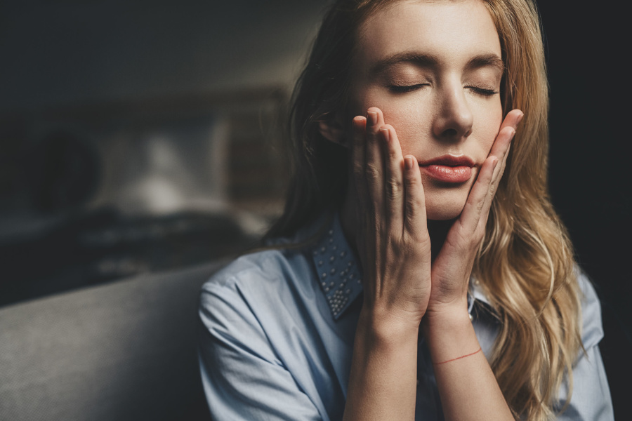 Why Dermaplaning is the Best Form of Exfoliation | Spotlyte woman with hands pressed to her face
