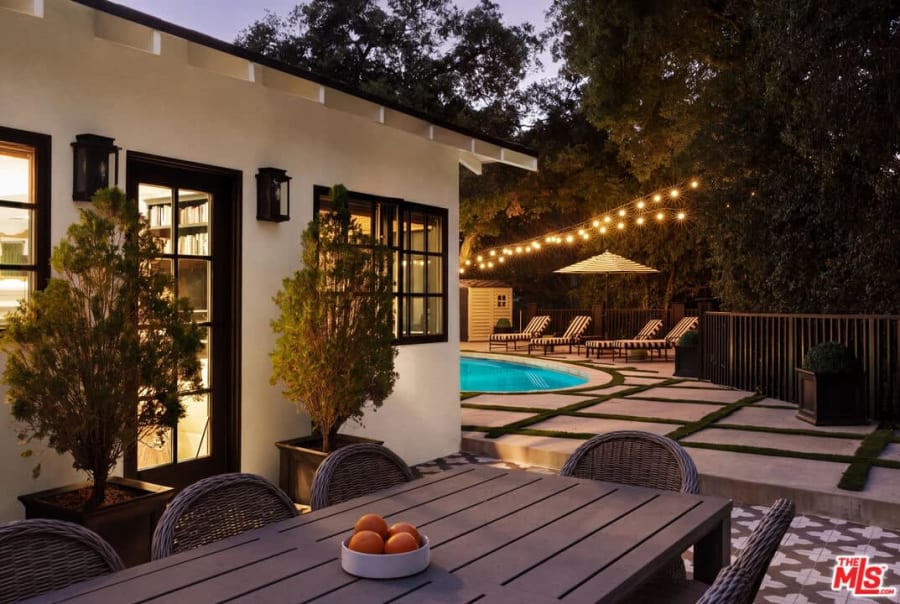 Outdoor dining table beside illuminated pool, 16822 Escalon Dr