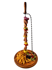 Spiedino di agnello alla griglia con patatine fritte e insalata