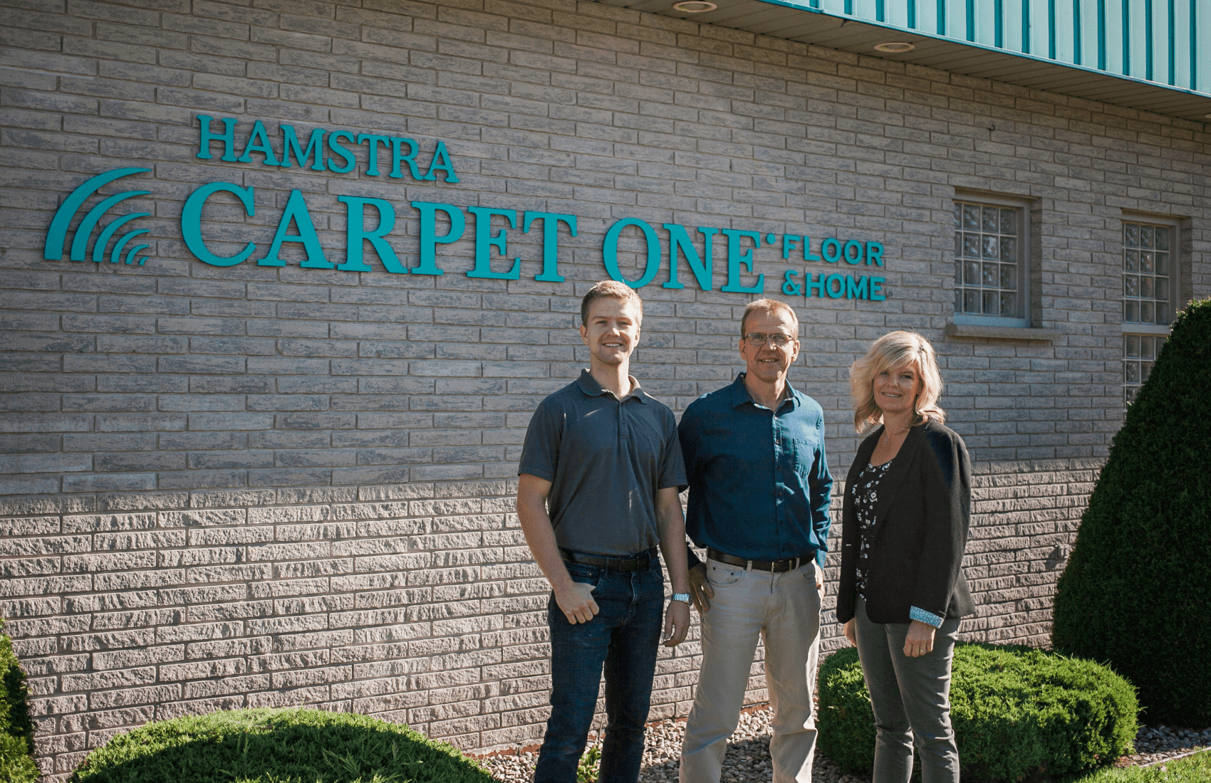 owners standing outside by sign