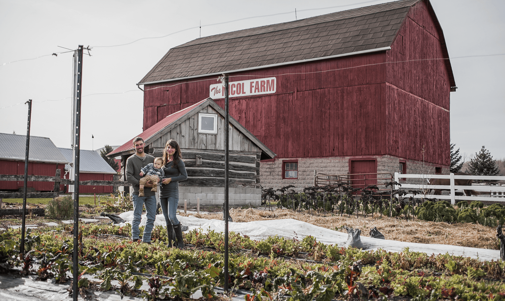 family standing in front of barn