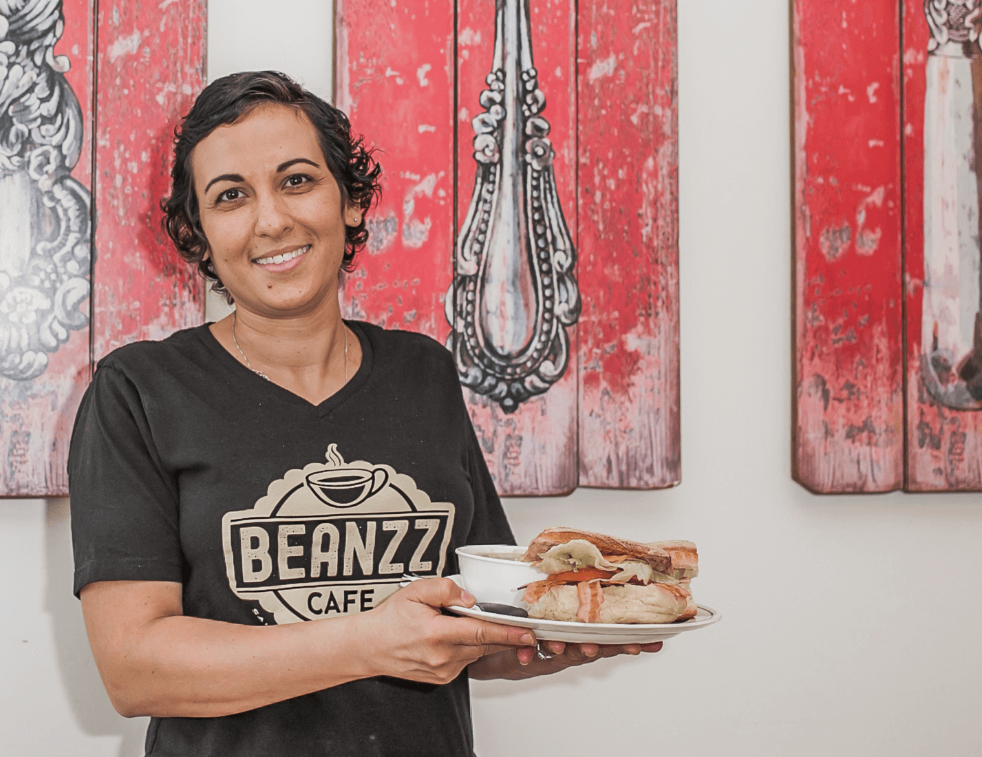 cafe owner holding sandwich