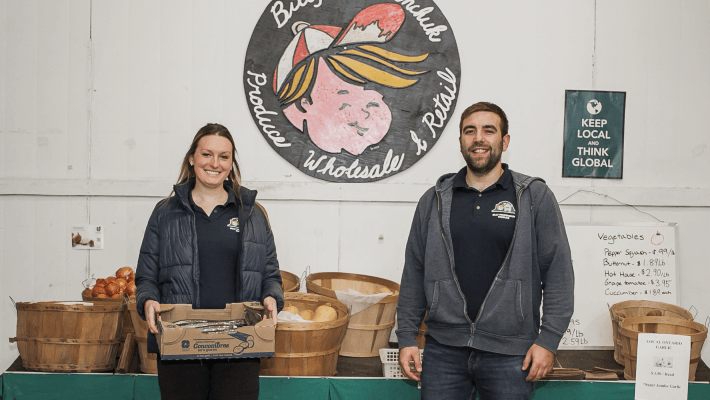 owners standing with produce