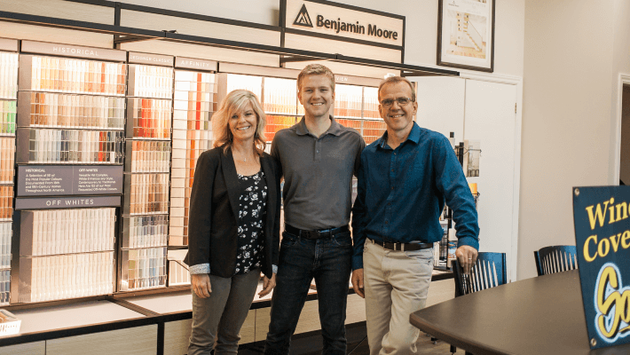 owners standing in front of paint wall