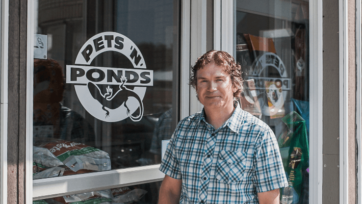 owner standing in front of front door of business