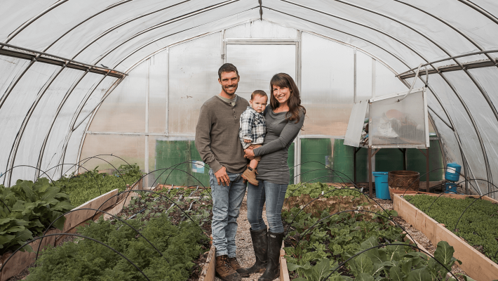 owners with son standing in greenhouse