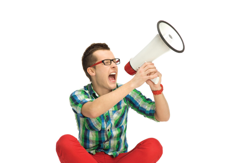 young man sitting and screaming into a megaphone