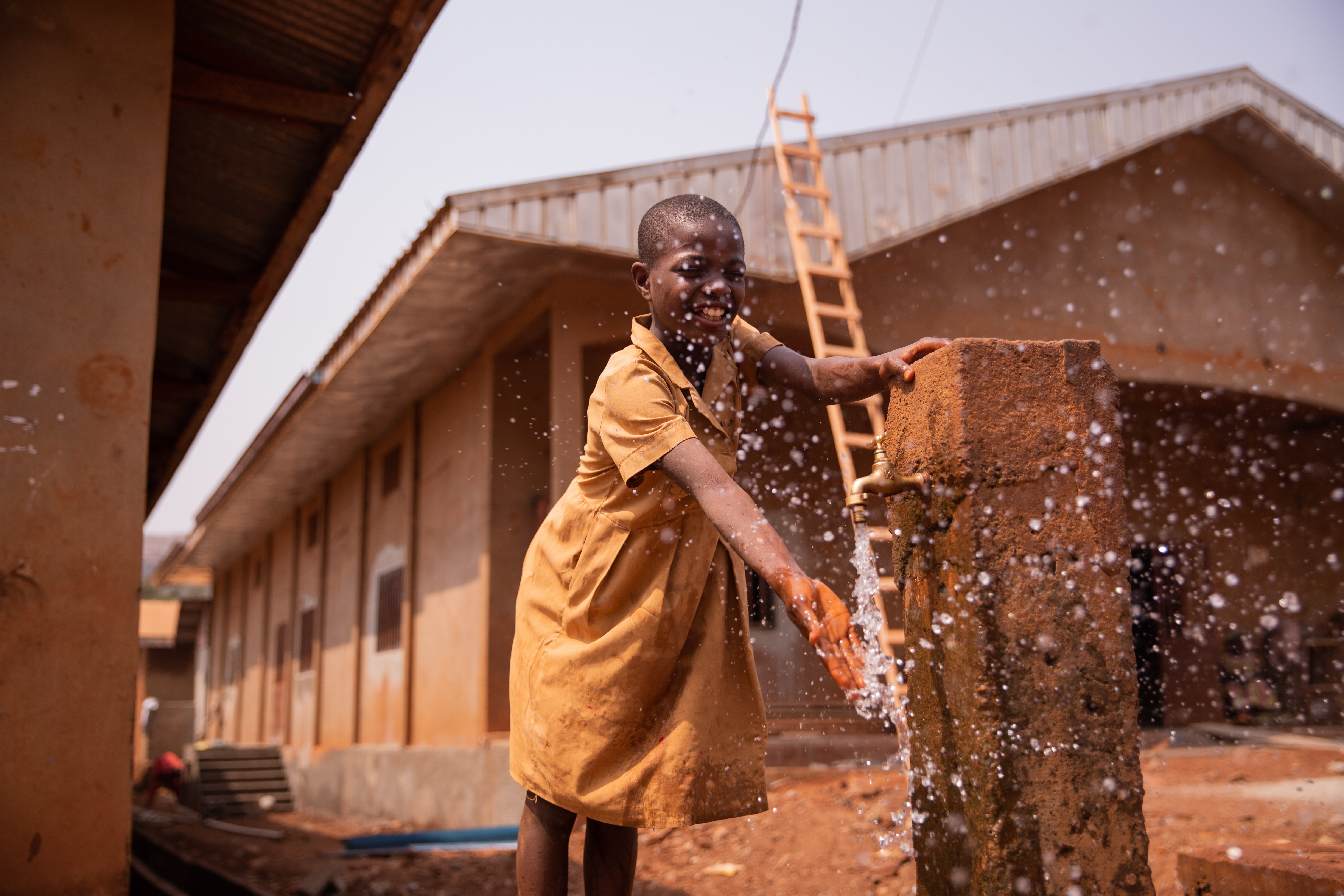 Schoolchild playing with splashing clean water