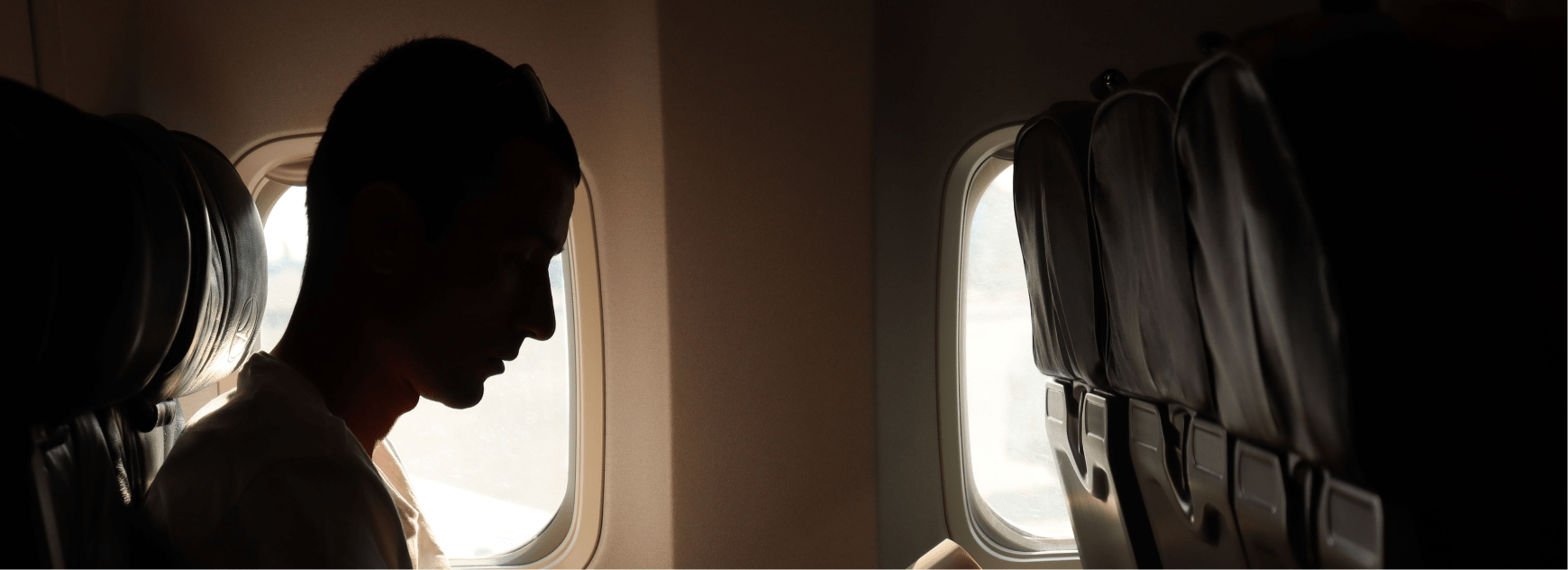 Traveler silhouette by an airplane window