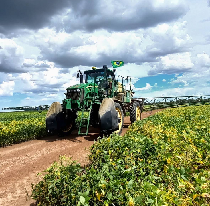 Trator pulverizador na lavoura de soja da Fazenda Campolina, sob céu nublado