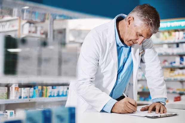 a doctor at a pharmacy writing a prescription