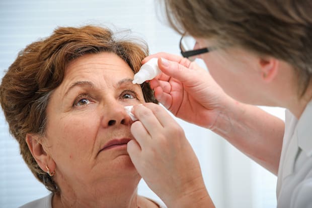 A woman inserting eye drops