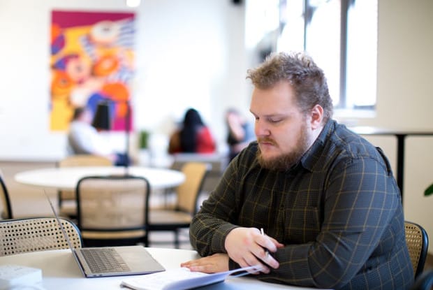 an overweight man working at a desk